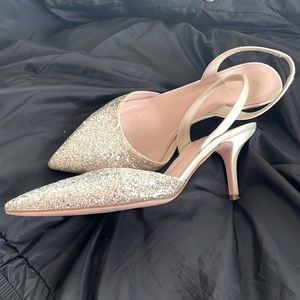 Kate Spade “Jeannette Silver/glitter Ivory Satin” pumps.